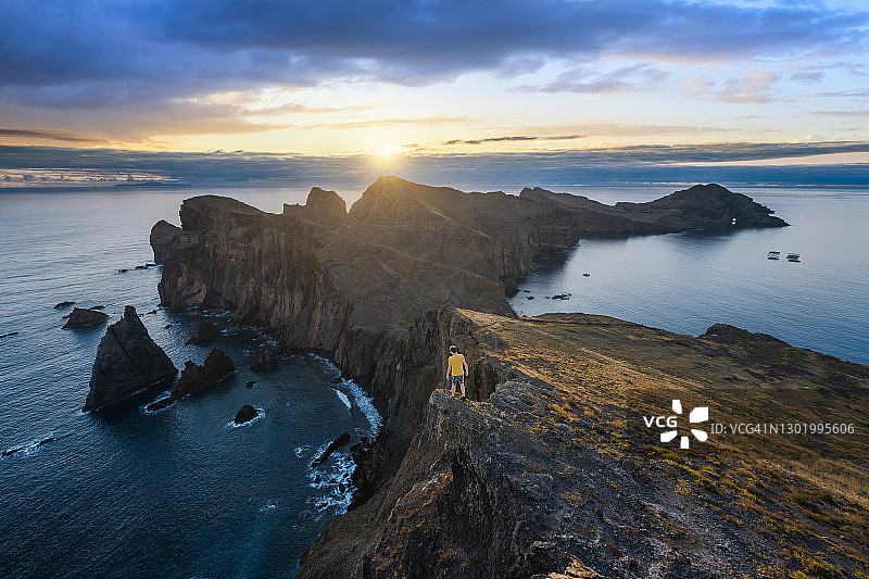 日出时一个人站在悬崖边，马德拉图片素材