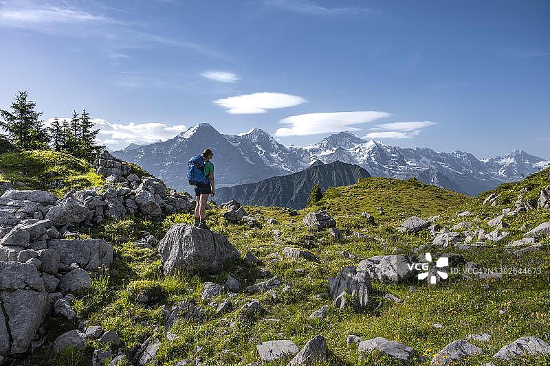 瑞士伯尔尼州格林德瓦尔德，少女区，徒步旅行者站在岩石上看山，施尼吉·普拉特山，后面的山顶图片素材