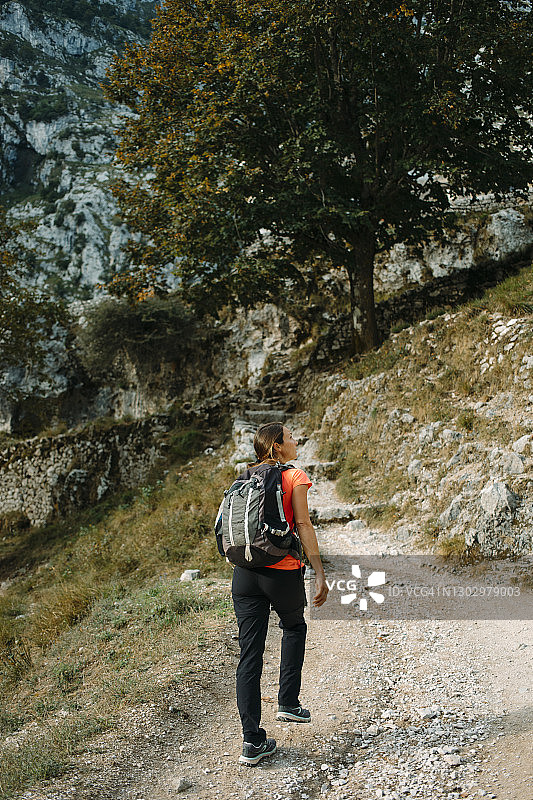 西班牙阿斯图里亚斯的Picos De Europe国家公园，徒步旅行者背着背包走在Cares Trail上，眼睛向别处看图片素材