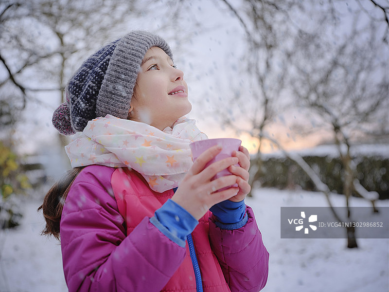 微笑的女孩在温暖的衣服拿着茶杯在冬天图片素材