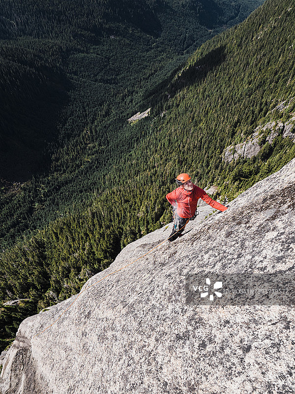 攀岩者在攀登BC省斯阔米什附近的一个高高的、偏僻的岩面时，将手放在粉笔袋里图片素材