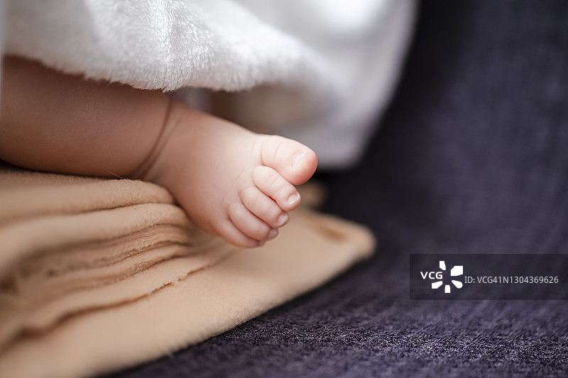 一个4周大的婴儿男孩的微距特写脚在淡黄色的毯子。水平图像组成图片素材