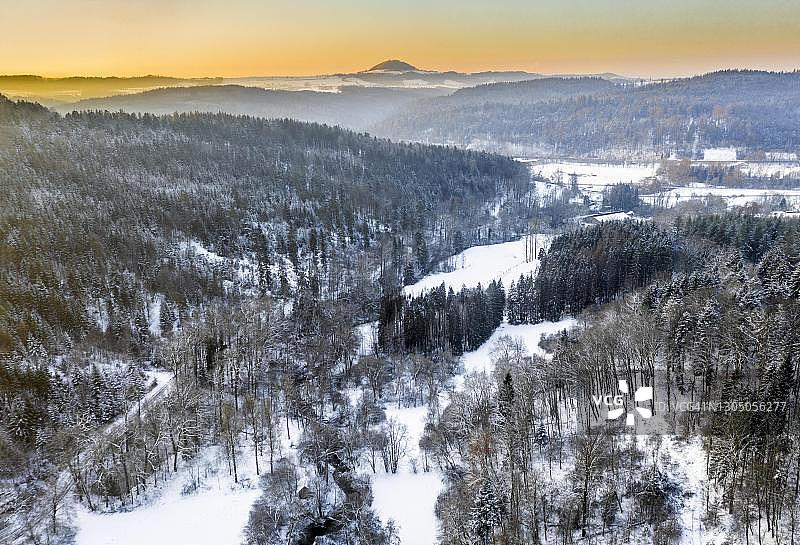 无人机拍摄的德国巴登-符腾堡州哈塞尔巴塔尔的斯瓦比亚森林、混交林里冬天有雪的景象图片素材