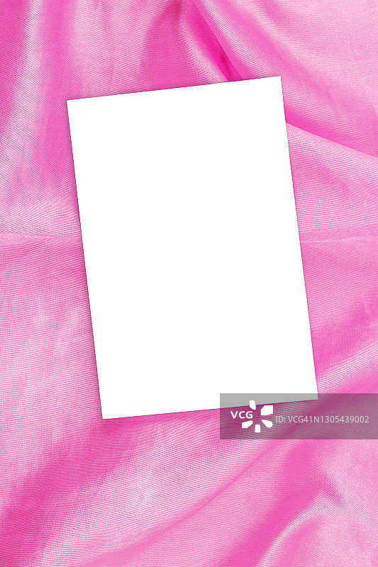 在柔软的粉红色织物上的白色名片模型，复制空间图片素材