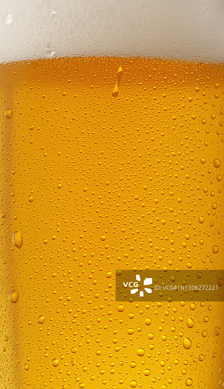 啤酒的背景。冰啤酒杯与水滴凝结垂直全景图片素材
