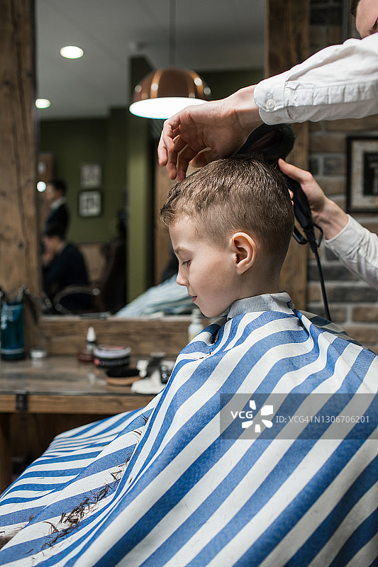 一个可爱的小男孩在理发店理发图片素材
