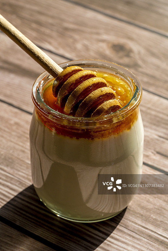 木头桌子上的蜂蜜酸奶图片素材