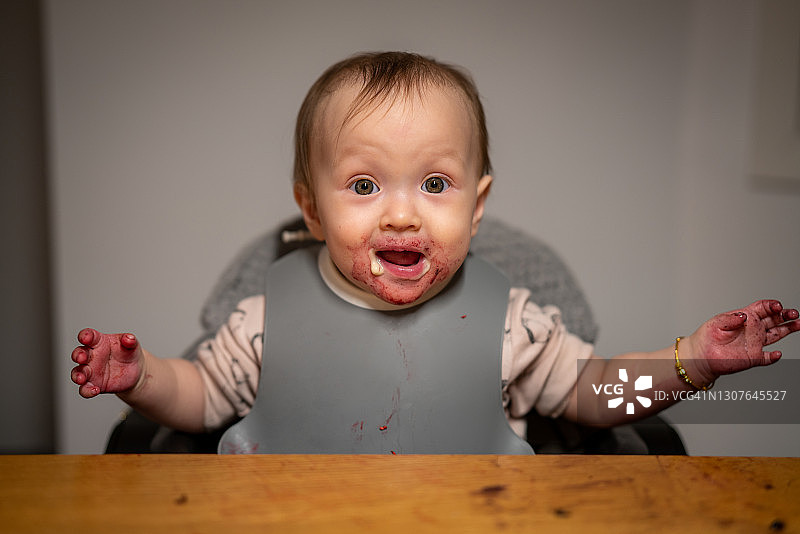 一个婴儿的脸上涂满了红酱图片素材