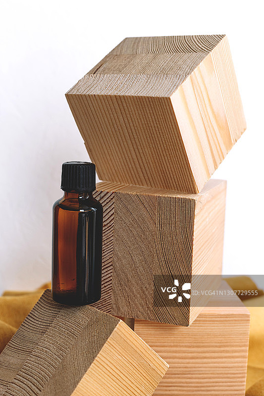 Spa化妆品在棕色的玻璃瓶在自然背景的木制立方体和黄色纺织品。模型。副本的空间。图片素材