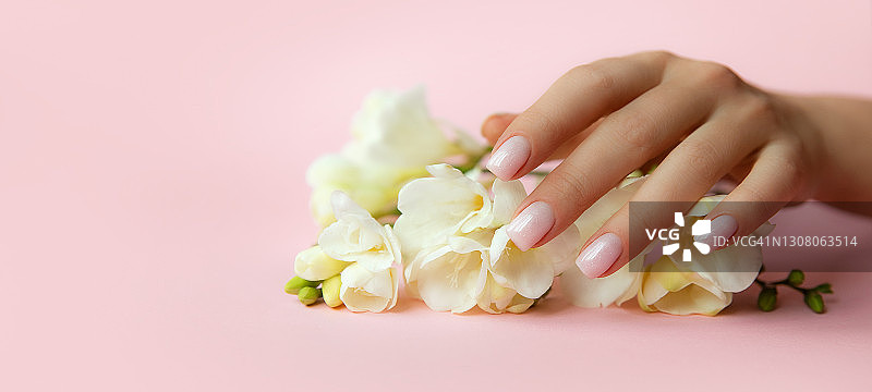 时尚的淡粉色米色指甲，粉红色背景上的花朵图片素材