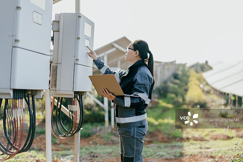 亚洲女工程师正在修理太阳能发电站的设备图片素材