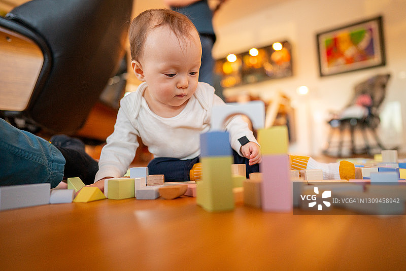 婴儿在地板上玩玩具积木图片素材