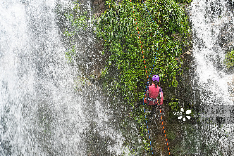 一位女攀登者掉进了瀑布图片素材