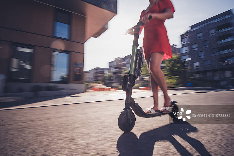 近距离观察不认识的女性在电动踏板车上图片素材