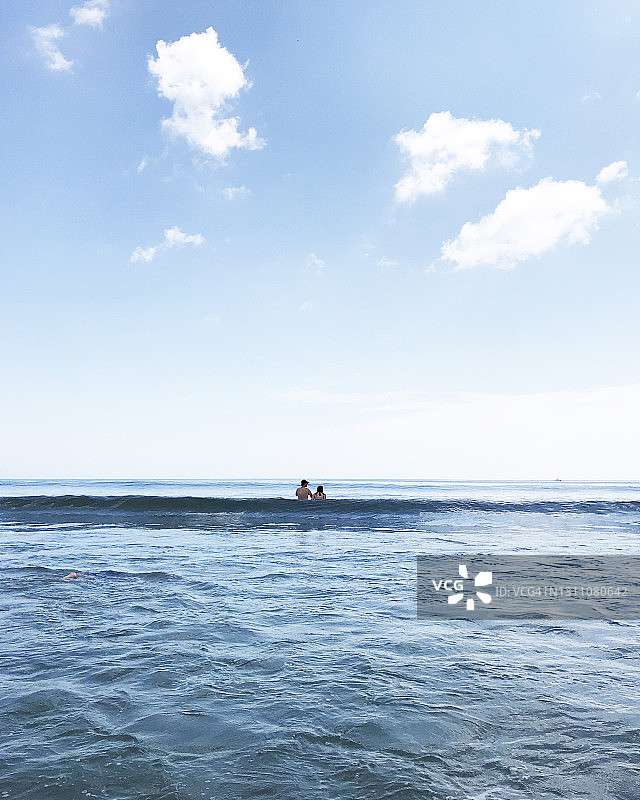 两个人站在海浪里图片素材