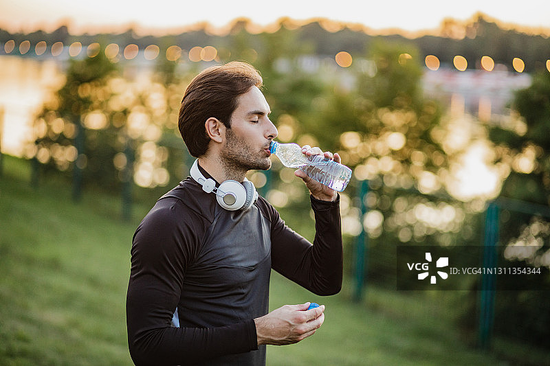 运动健硕的年轻人穿着运动服正在喝水和休息图片素材