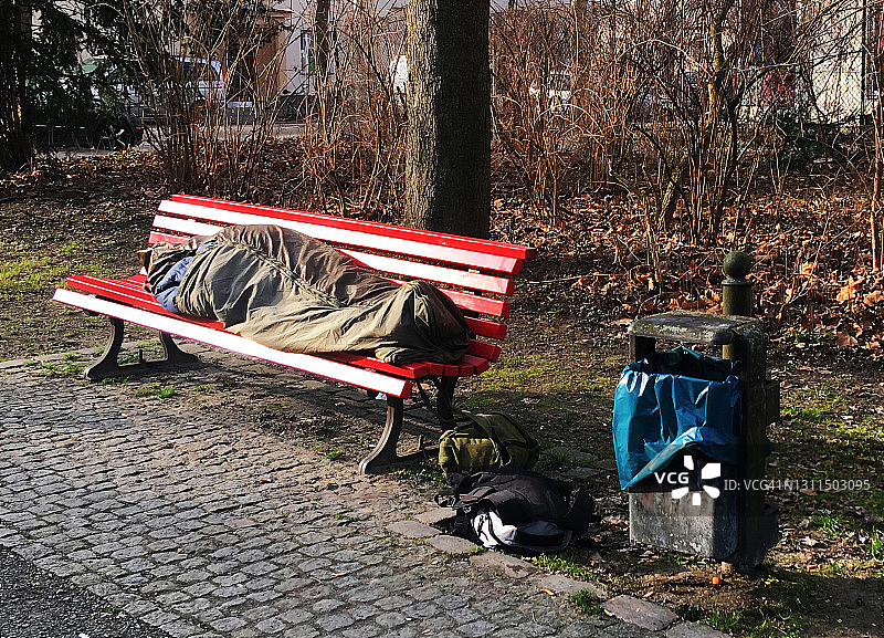 无家可归，睡在公园的长椅上图片素材