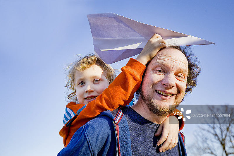 快乐的男人背着女儿拿着纸飞机图片素材