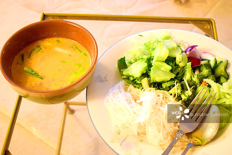 Kanum Jeen Nam Ya或粉丝米粉与鸡肉椰奶咖喱，配菜有很多新鲜蔬菜。健康辛辣的泰国食物。图片素材