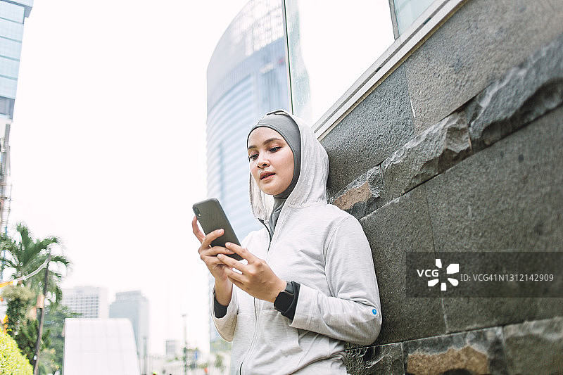 一名印尼妇女正在查看她的智能手机图片素材