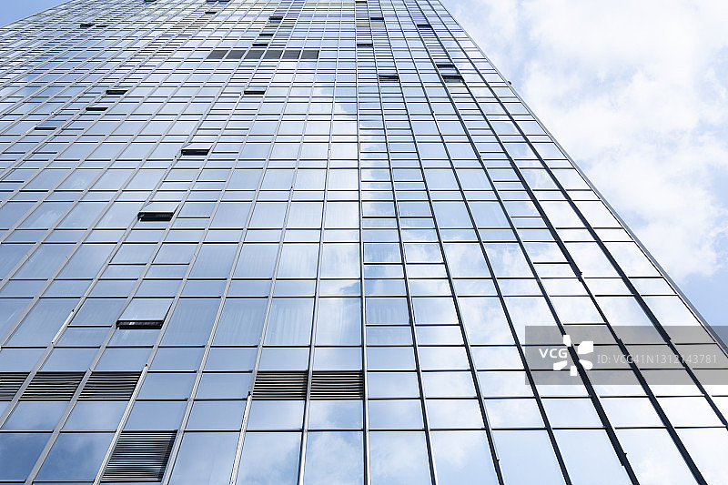 现代的玻璃办公建筑反射着蓝天白云图片素材