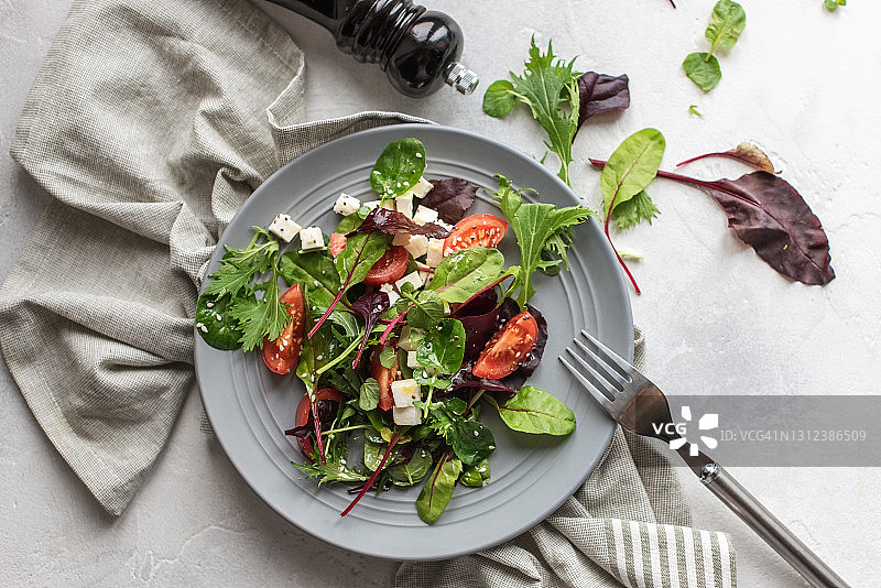 牛油果，西红柿和黄瓜沙拉新鲜的香草在黑色的石头背景。健康的夏季沙拉。本空间图片素材