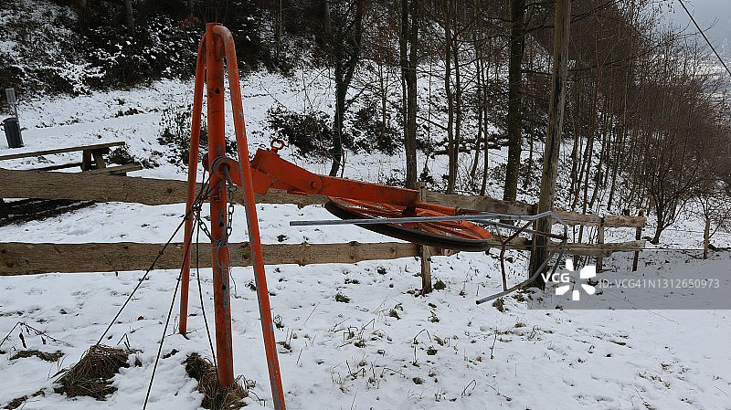 古董滑雪升降机熨烫升降机在红色大圆形滚柱钢丝绳和拉手拉在蒂罗尔图片素材
