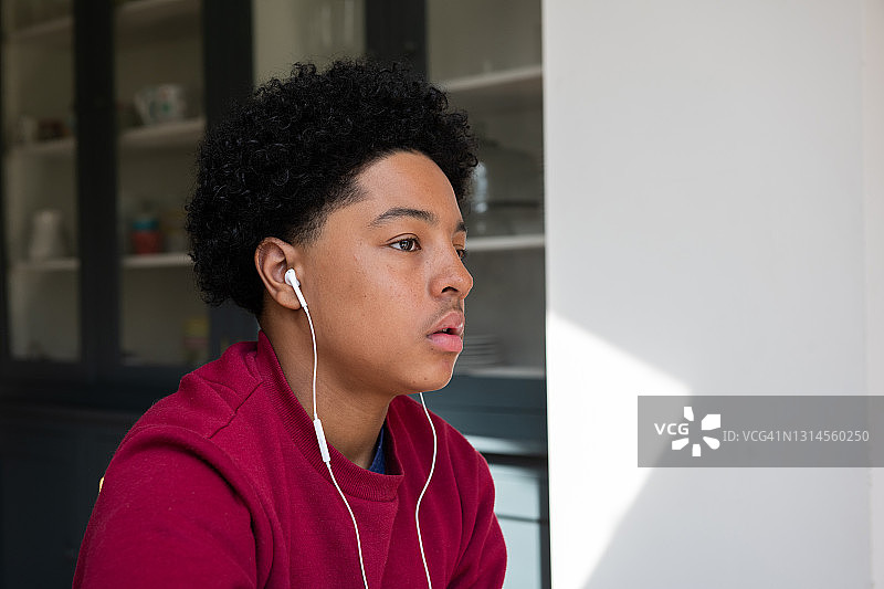 十几岁的男孩戴着耳机听音乐图片素材