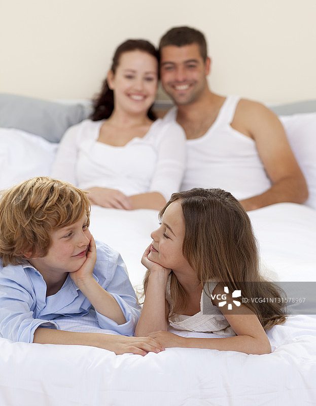 弟弟和妹妹和她的父母在床上图片素材