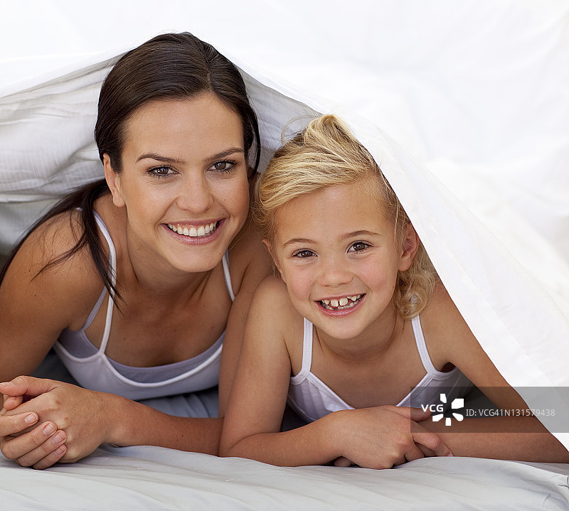 妈妈和女儿躺在床单下面图片素材