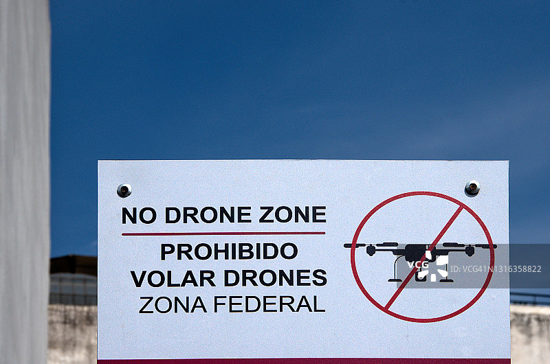 双语的英语和西班牙语标志，上面写着“禁止无人机区/禁止无人机。”带联邦的图片素材