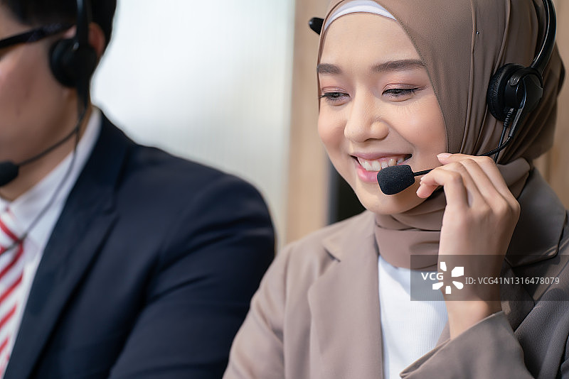 商务女性穆斯林呼叫中心在办公室。客户服务支持。呼叫中心服务团队。图片素材