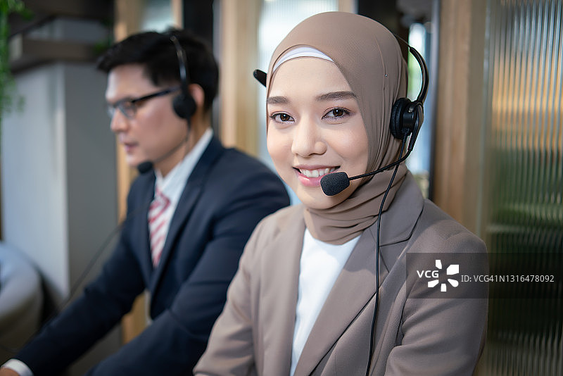 商务女性穆斯林呼叫中心在办公室。客户服务支持。呼叫中心服务团队。图片素材