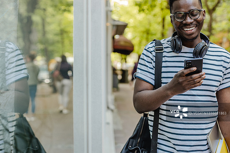 非裔美国人自信的年轻人正在大街上使用手机图片素材