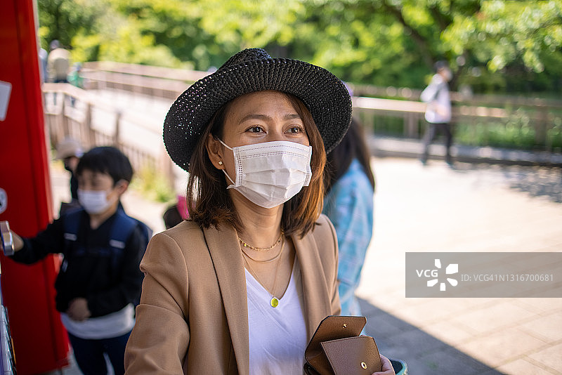 亚洲家庭戴着防护口罩在公园散步图片素材