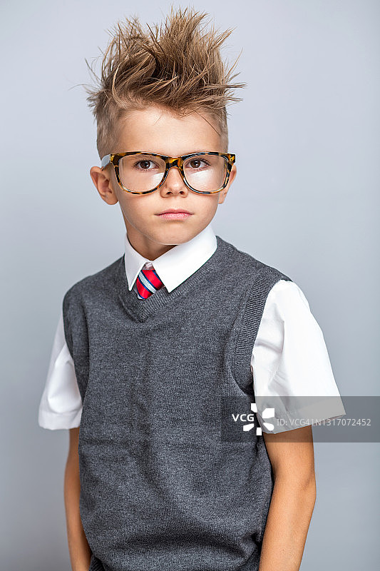 滑稽可爱的小男孩穿着优雅的校服图片素材