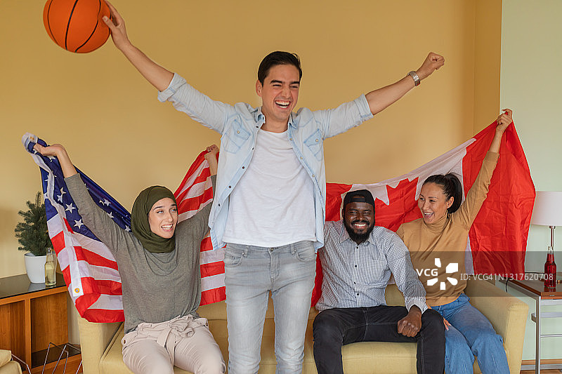 来自不同种族的朋友正在支持美国和加拿大的国家篮球队。图片素材
