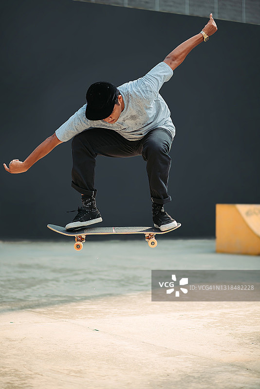 亚洲男性滑板运动员在滑板公园里呼吸新鲜空气图片素材