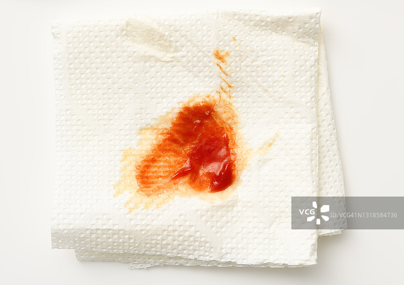 用白纸餐巾去除番茄酱污渍。图片素材
