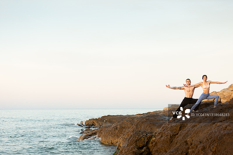 女人和男人在海滩上练瑜伽图片素材