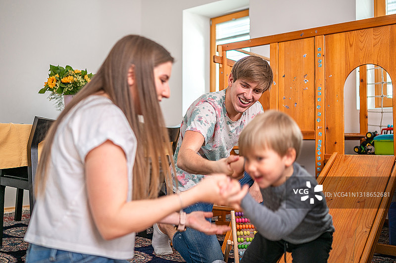 年轻的家庭和一个孩子在家里玩图片素材