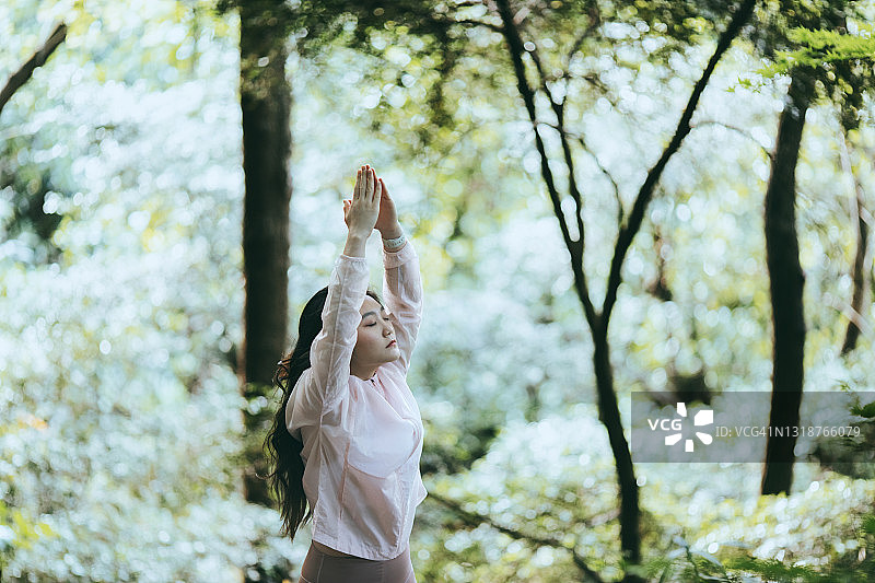 一个年轻女子在森林里做瑜伽图片素材