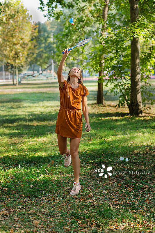 年轻的妈妈正在公园里玩羽毛球。图片素材