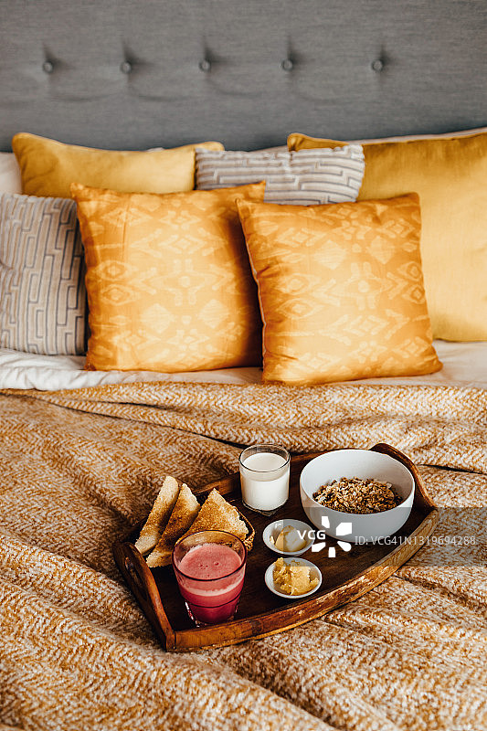舒适的卧室里，健康的早餐放在床上。图片素材