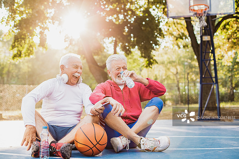 活跃的老年人在篮球场上从体育活动中休息图片素材