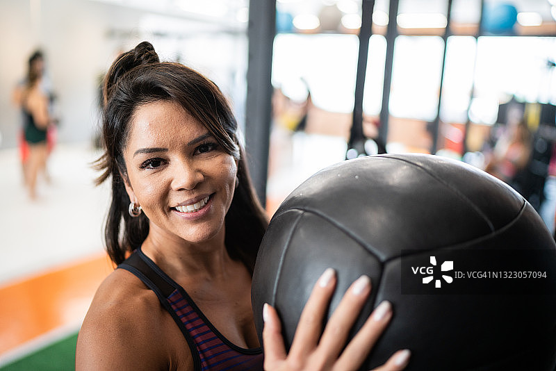 一个成熟的女人在健身房用健身球锻炼的肖像图片素材