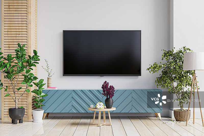 模拟电视墙安装在一个白色的客厅的橱柜上。图片素材