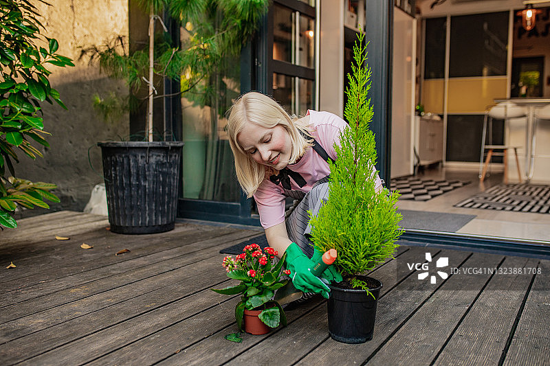 一个年轻的女人喜欢园艺和照顾室内植物图片素材