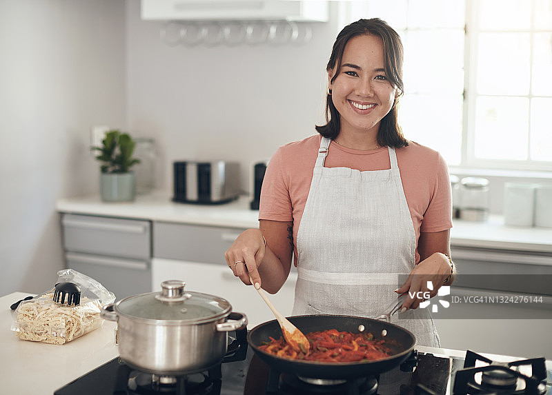 一个年轻女子在家做饭的照片图片素材