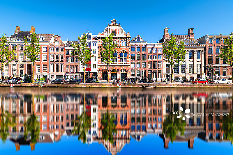 白天阿姆斯特丹一条平静的运河上的倒影图片素材